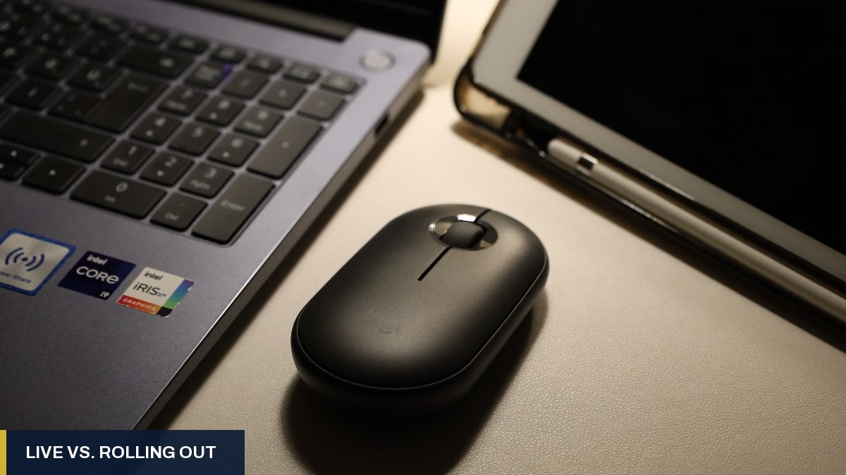 Close-up of a laptop keyboard, wireless mouse and tablet on a desk
