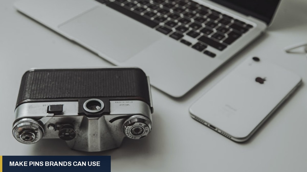 Vintage camera beside a laptop and smartphone on a light desk