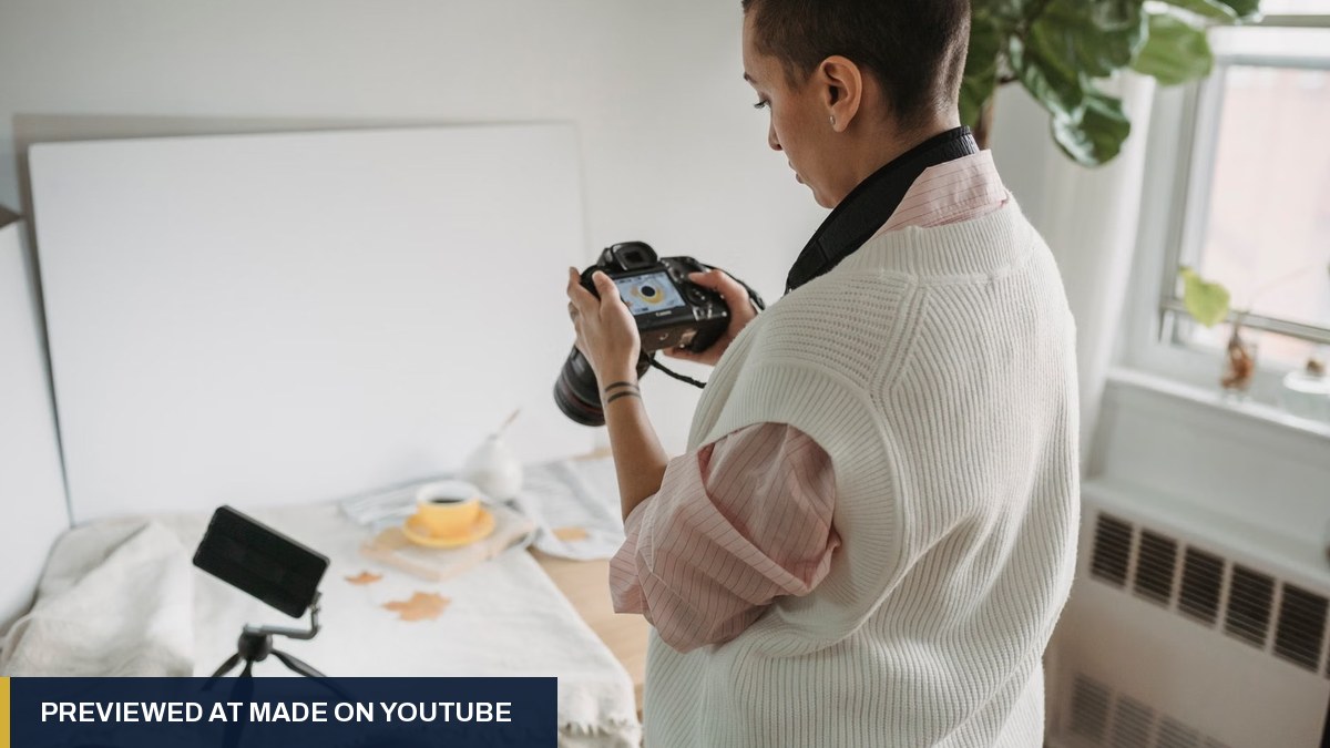 Creator checking a photo on her camera beside a phone on a mini tripod